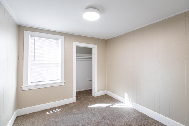 unfurnished bedroom featuring carpet floors, a closet, visible vents, and baseboards