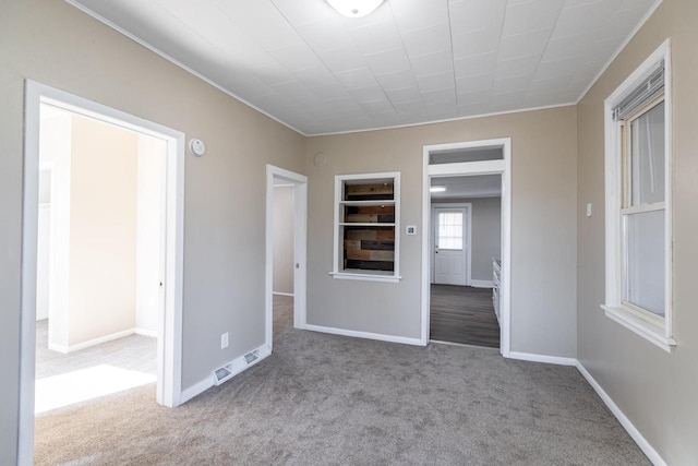 carpeted empty room featuring visible vents and baseboards