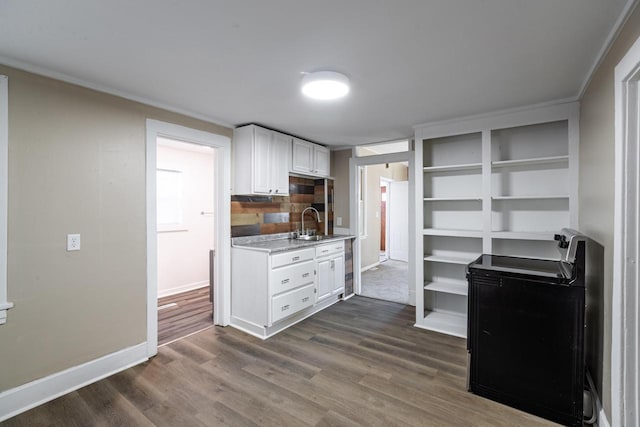 kitchen featuring electric stove, dark wood-style flooring, light countertops, white cabinets, and a sink