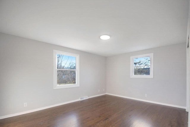 empty room with baseboards, visible vents, and a healthy amount of sunlight