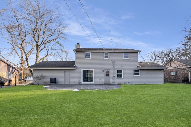 back of house featuring a yard, a chimney, and a patio