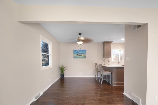 unfurnished dining area featuring dark wood-style floors, visible vents, and baseboards