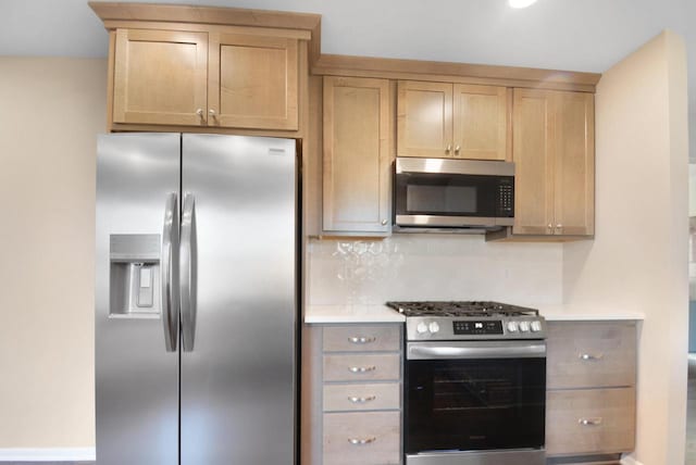 kitchen featuring stainless steel appliances, light countertops, backsplash, and light brown cabinets