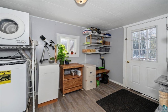 clothes washing area featuring wood finished floors, stacked washer and clothes dryer, and laundry area