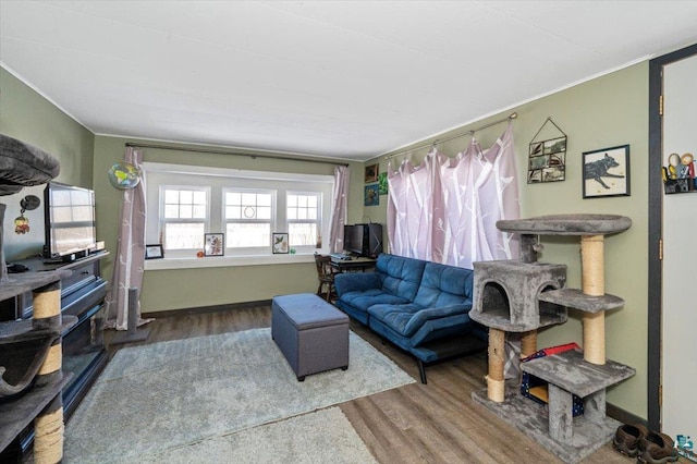 living room with ornamental molding, wood finished floors, and baseboards