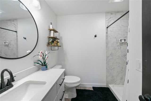 full bath featuring toilet, a shower stall, baseboards, and vanity