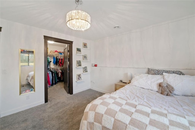 bedroom with baseboards, carpet, a spacious closet, a chandelier, and a closet