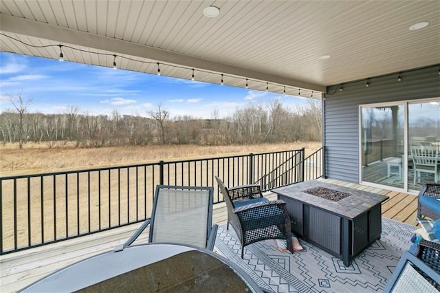 wooden deck with an outdoor fire pit and outdoor dining area