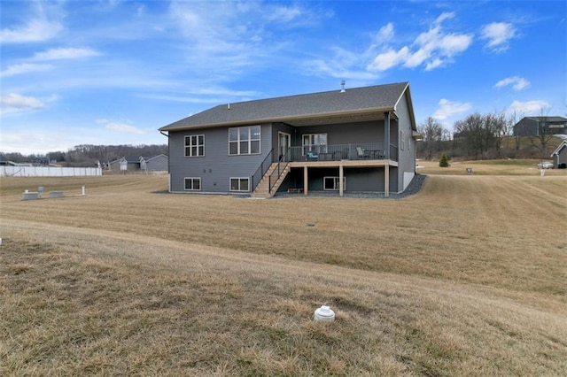 back of house with stairway, a deck, and a yard