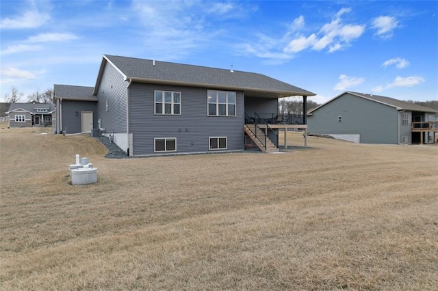 rear view of house with stairs, a yard, and a deck