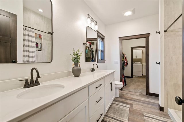 bathroom with a shower with curtain, a sink, and independent washer and dryer