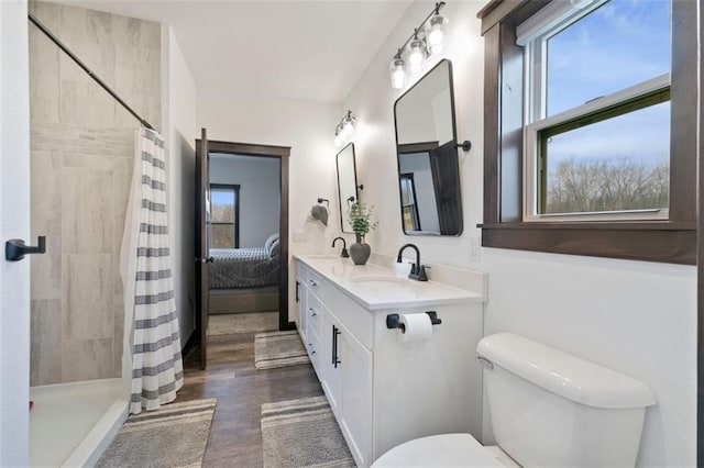 full bath featuring a sink, a tile shower, and toilet