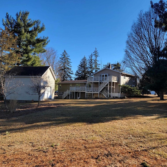 back of house featuring stairs, a yard, and a wooden deck