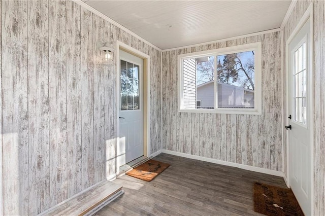 interior space featuring baseboards, wood finished floors, and ornamental molding