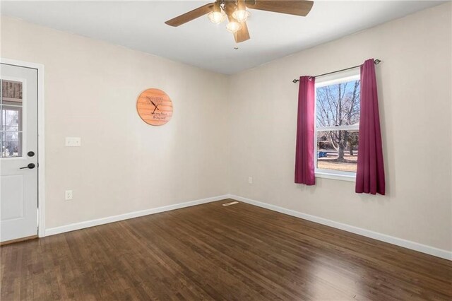 empty room featuring ceiling fan, baseboards, and wood finished floors