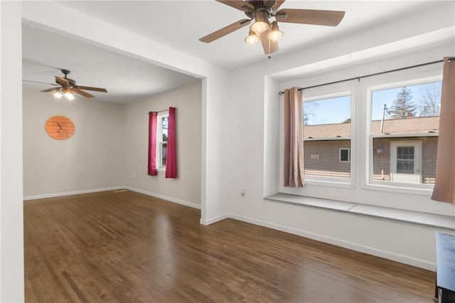 empty room with ceiling fan, baseboards, and wood finished floors