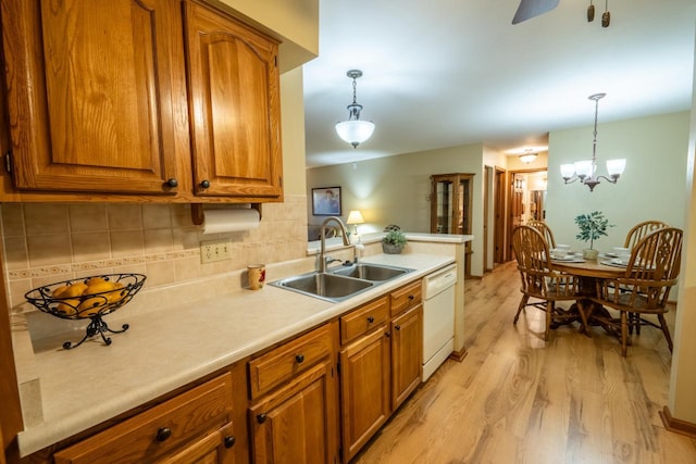 kitchen featuring light countertops, brown cabinets, a sink, and white dishwasher