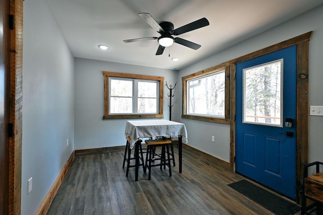 dining space with dark wood finished floors, a ceiling fan, and baseboards