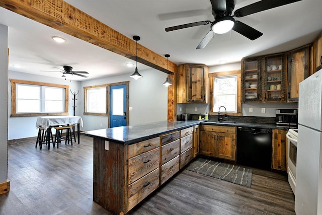 kitchen featuring dark wood-style flooring, hanging light fixtures, a sink, white appliances, and a peninsula