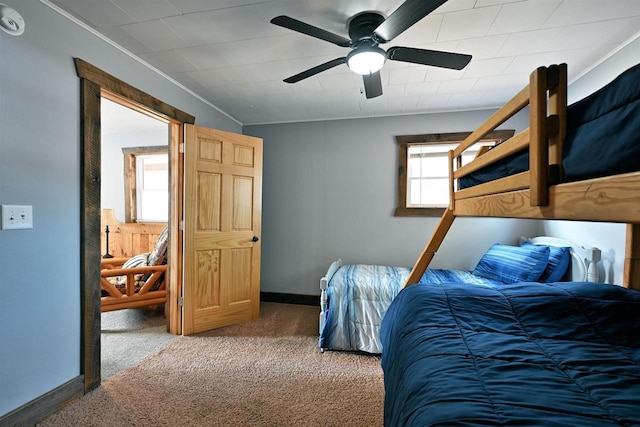 bedroom with ceiling fan, baseboards, carpet flooring, and ornamental molding