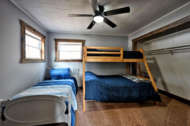 carpeted bedroom with a ceiling fan and baseboards