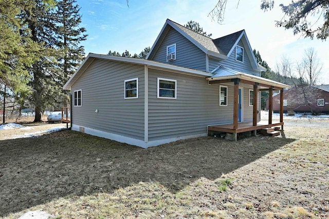 rear view of property featuring a shingled roof and covered porch