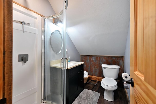 full bathroom with lofted ceiling, a shower stall, toilet, and wood finished floors