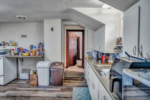 kitchen featuring white cabinetry, electric range, a textured ceiling, and wood finished floors