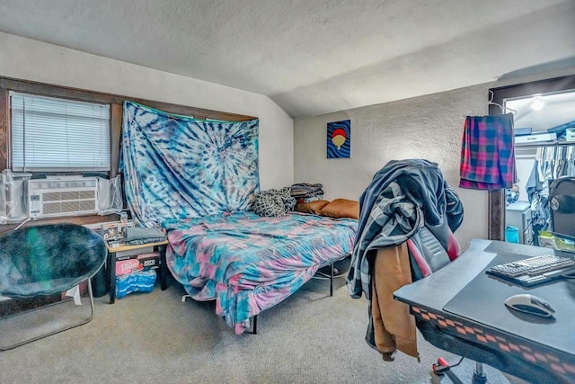 carpeted bedroom featuring cooling unit, vaulted ceiling, a textured ceiling, and a textured wall