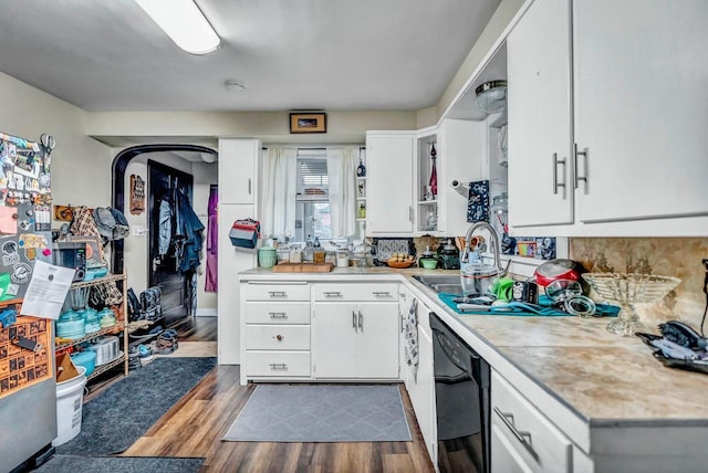 kitchen featuring black dishwasher, dark wood-style flooring, light countertops, and a sink