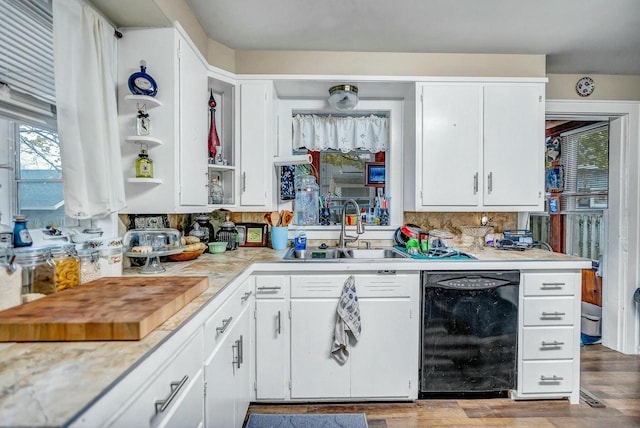 kitchen featuring dishwasher, wood finished floors, light countertops, white cabinetry, and a sink