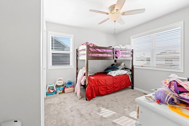 carpeted bedroom with ceiling fan and baseboards