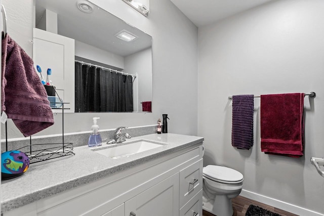 full bath featuring toilet, vanity, wood finished floors, a shower with curtain, and baseboards