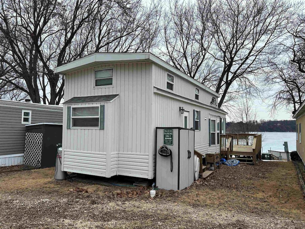 view of side of home with a deck with water view