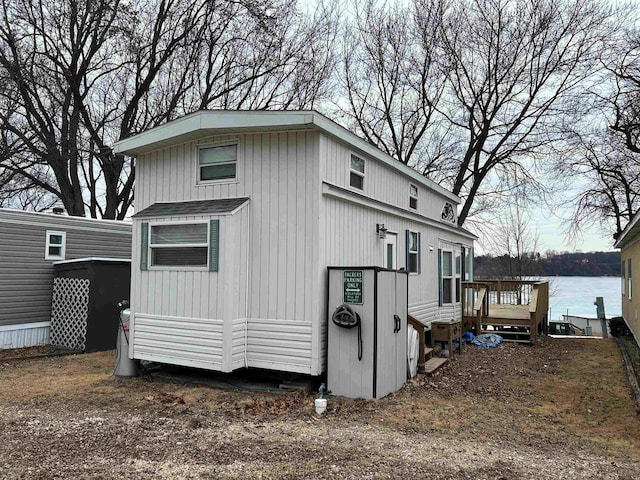 view of side of home with a deck with water view