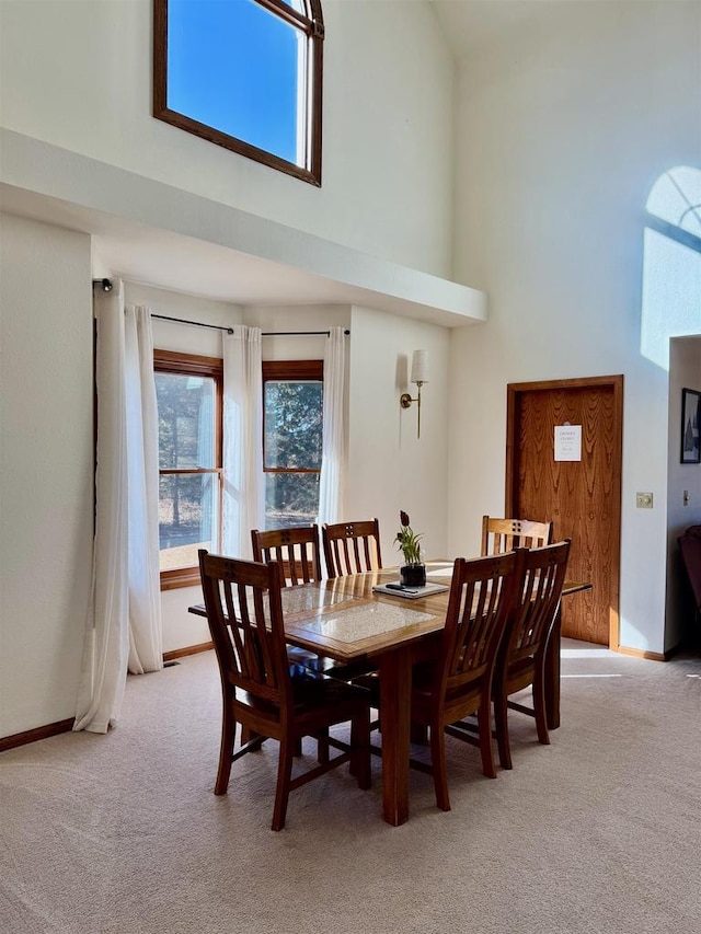 N3820 Fairwood Rd, Reeseville, WI 53579 - dining space featuring a towering ceiling, light carpet, and baseboards