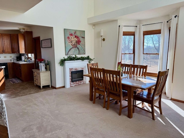 N3820 Fairwood Rd, Reeseville, WI 53579 - dining space with light colored carpet, a brick fireplace, baseboards, and a towering ceiling