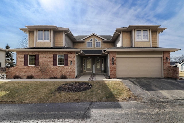 view of front of property featuring brick siding, an attached garage, and aphalt driveway