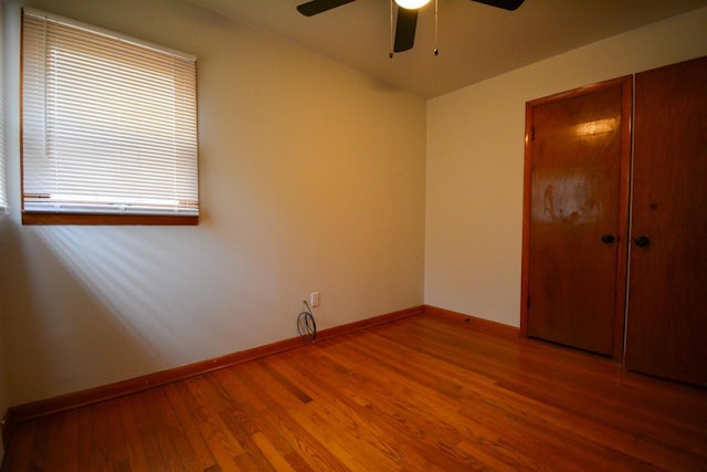 spare room featuring ceiling fan, baseboards, and wood finished floors