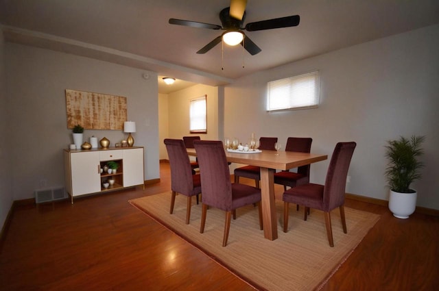 dining area with a ceiling fan, baseboards, visible vents, and wood finished floors