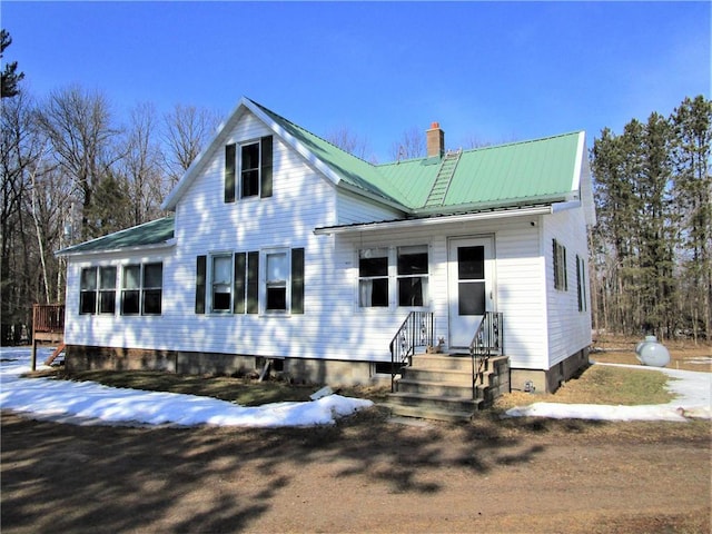 view of front of home with metal roof and a chimney