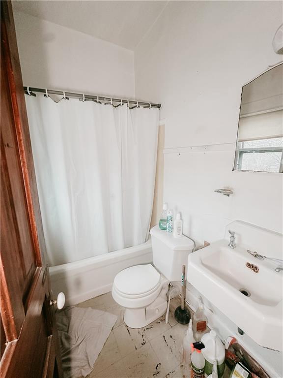 full bathroom with shower / bath combo, a sink, and toilet