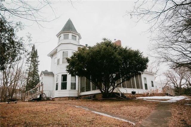 view of property exterior with a sunroom