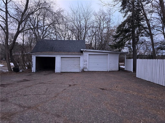 detached garage featuring fence