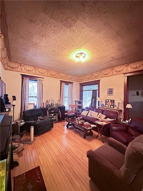 living room featuring plenty of natural light, a textured ceiling, and hardwood / wood-style flooring