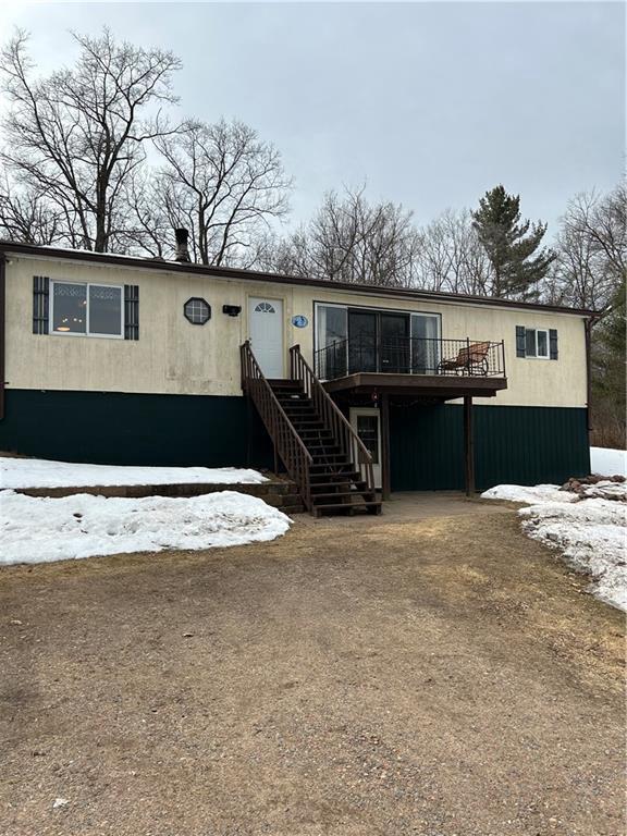 view of front facade featuring a deck, driveway, and stairway