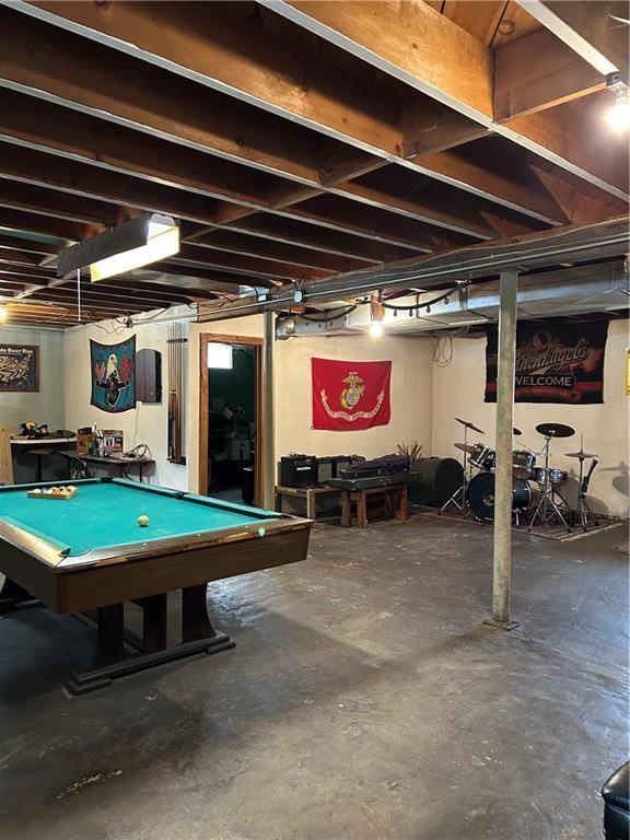 interior space featuring billiards and unfinished concrete flooring