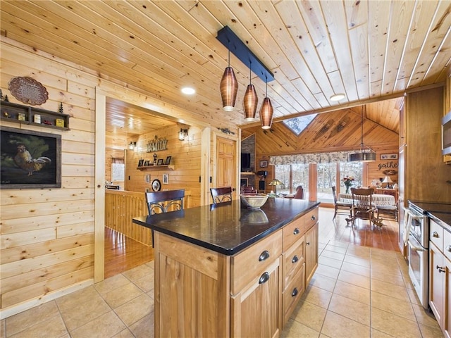 kitchen featuring vaulted ceiling with skylight, wooden ceiling, wooden walls, and light tile patterned floors