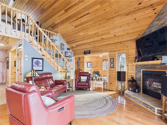 living room featuring wood ceiling, wooden walls, and stairs