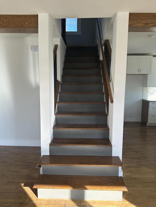 staircase with wood finished floors and baseboards